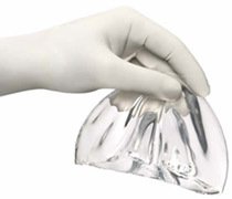 Gloves holding breast implant