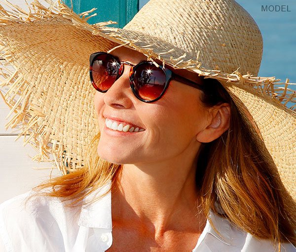 Female model wearing a sunhat and sunglasses at beach