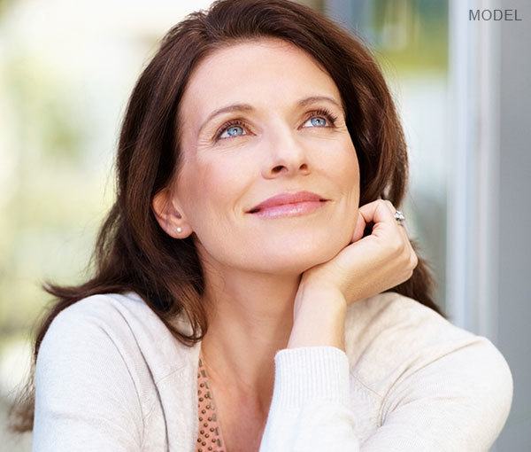 Model sitting down with hand under chin